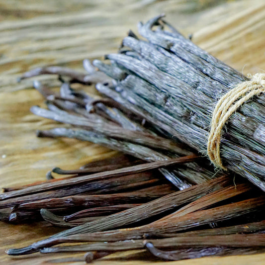 Bundled vanilla beans on a wooden surface